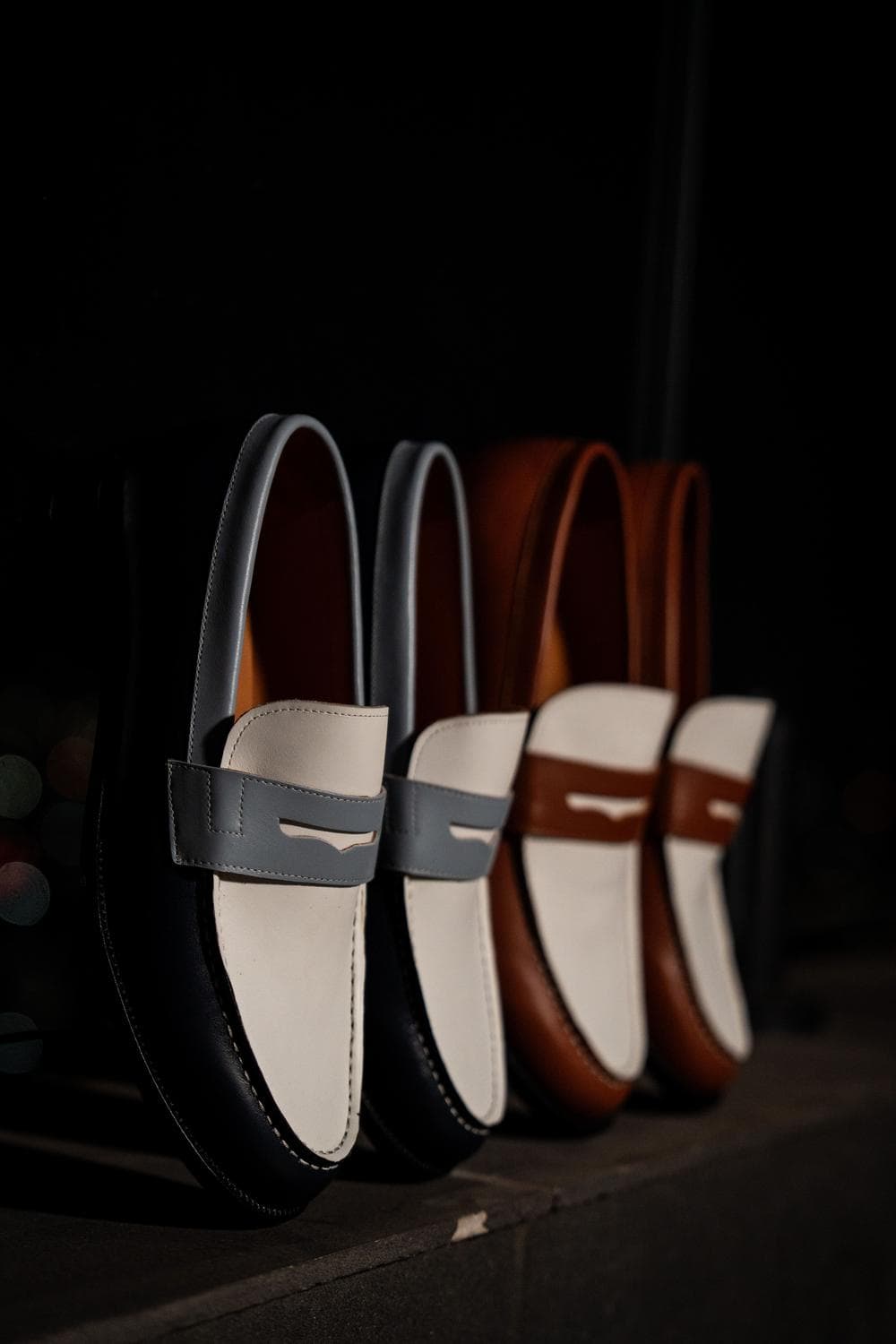 Penny loafers lined up in a row above the city at night